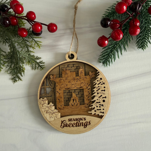 3 layer Chrismas Ornament with Bricks, Window and Fireplace in the background with pile of presents on the left and Christmas Tree on the right with "Season Greetings" engraved in the bottom. Ornament is 3 layers of wood. 