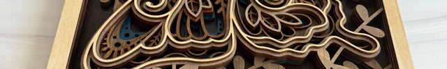 Close-up angled shot of a 3D layered butterfly wood wall art showing the depth of six stacked maple layers and detailed mandala-style wing engravings