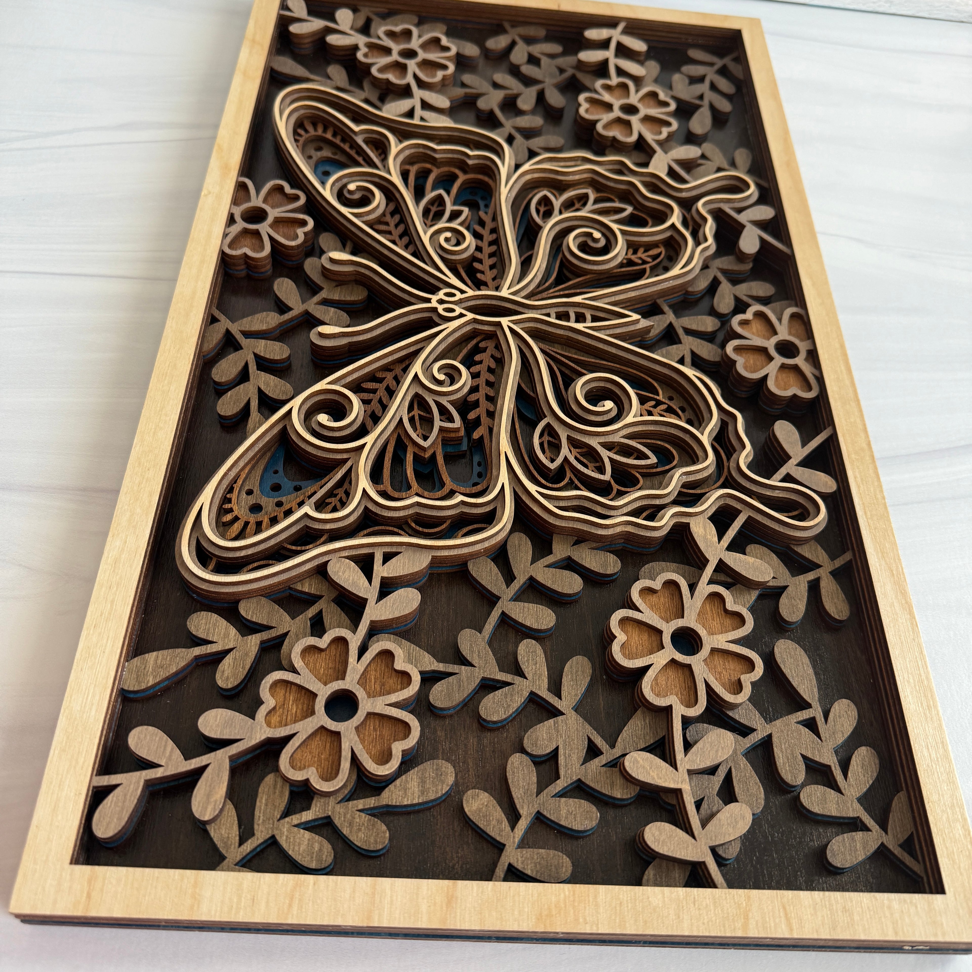 Side profile of a 3D butterfly sign highlighting the 5-layer premium plywood construction and hand-assembled floral details