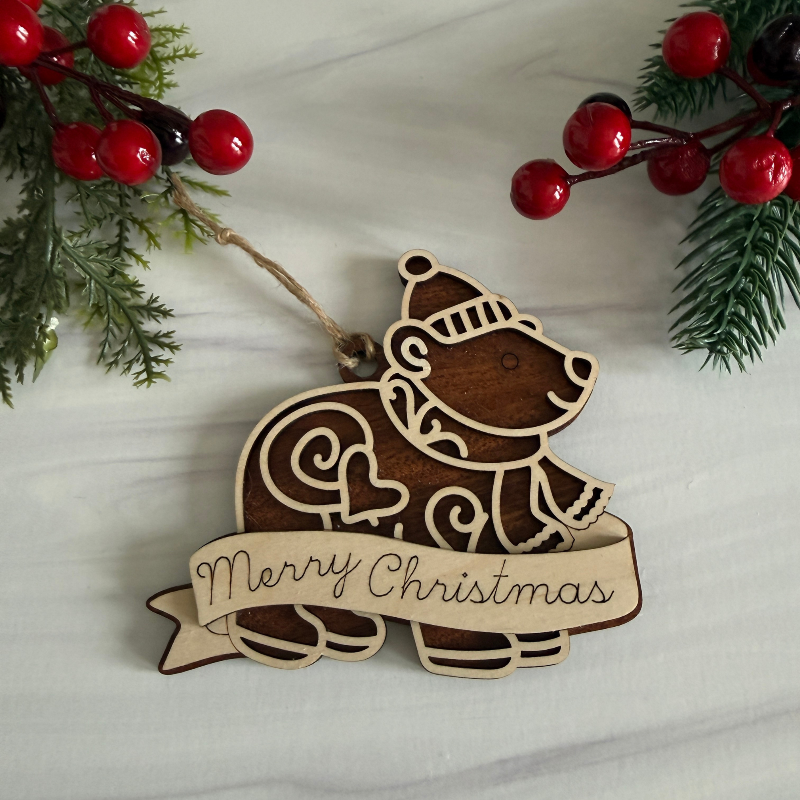 Wooden Christmas ornament shaped like a bear with personalization on Maple and Mahogany wood by Cactus Air Designs.