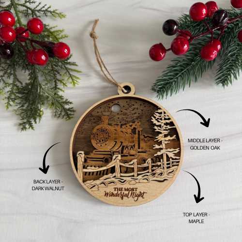 Wooden Christmas ornament with layered design and train illustration, surrounded by festive decorations.