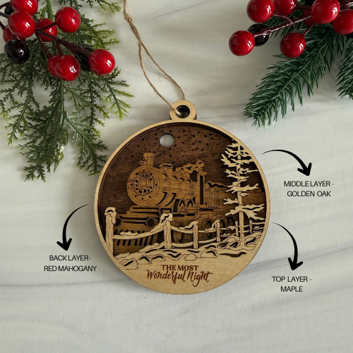 Wooden ornament with train design, layered wood finish, and 'The Most Wonderful Night' text, surrounded by Christmas decorations.