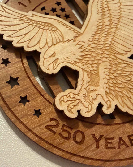 Closeup detail of laser cut bald eagle and American flag on USA 250 Years of Freedom wood ornament showing maple and cherry layers
