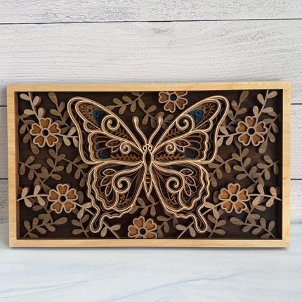 Butterfly layered wood wall art front view showing intricate mandala wing detail and full floral border in natural maple plywood with dark background