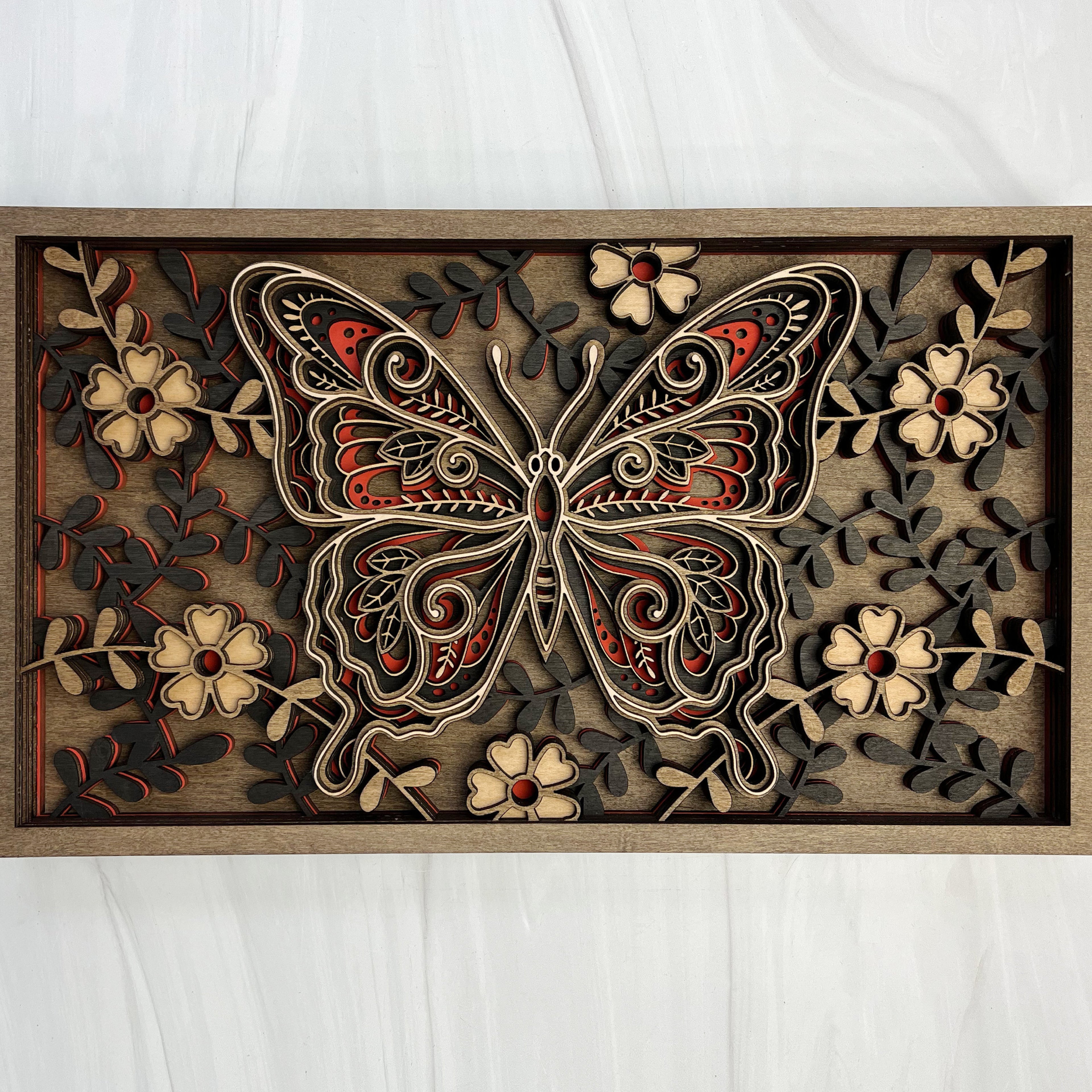 6-layer 3D laser cut wood butterfly wall art featuring intricate floral  patterns and red accents in a natural wood frame by Cactus Air Designs.