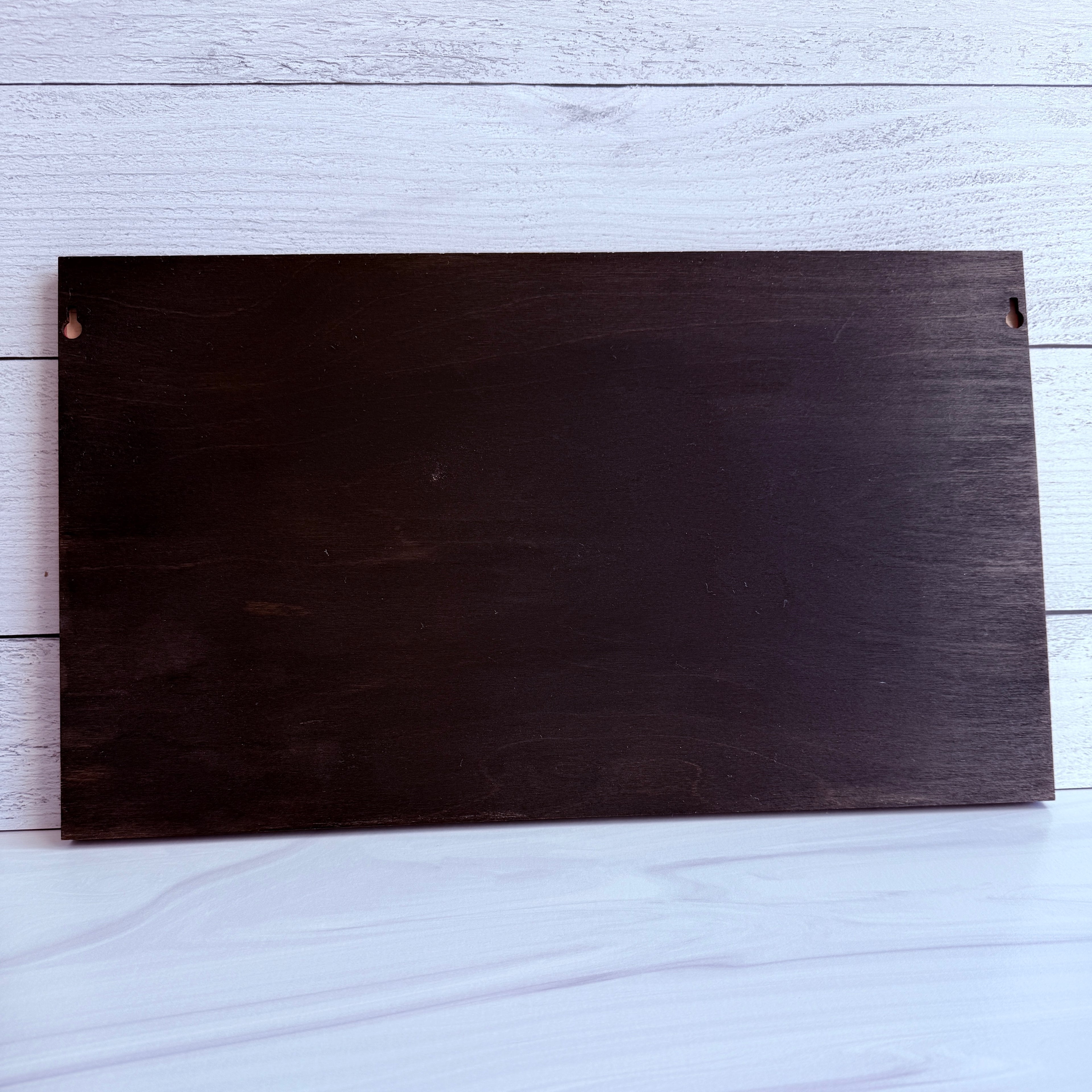 Rear view of 10.5 inch by 18 inch wood wall art showing the dark-stained back and built-in keyhole hangers for secure wall mounting.