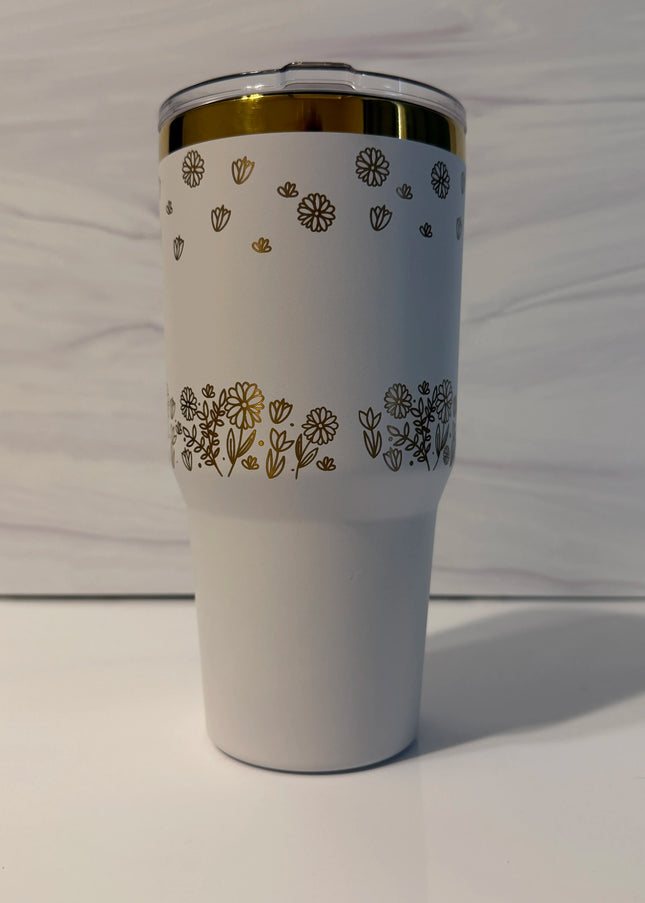 Alt text: Back view of white and gold electroplated laser-engraved tumbler showing full floral meadow wrap design by Cactus Air Designs
