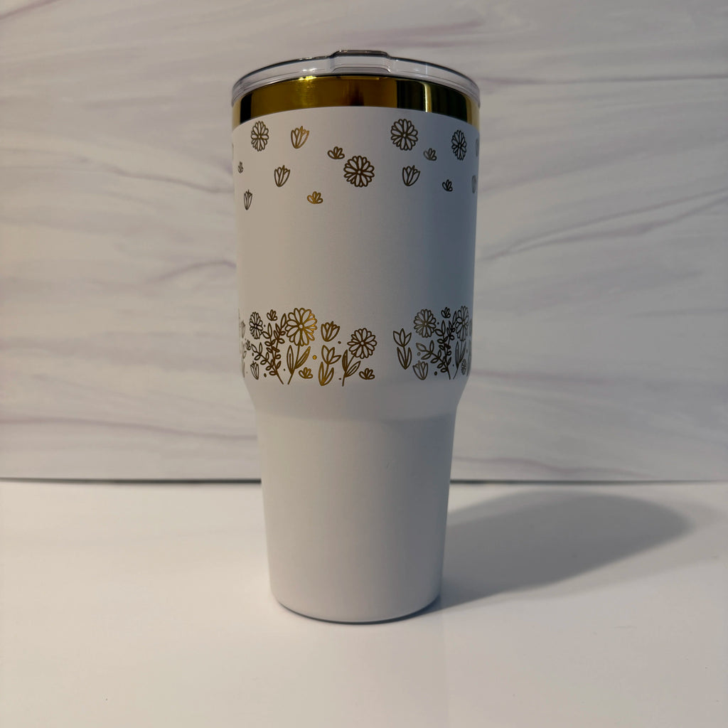 Alt text: Back view of white and gold electroplated laser-engraved tumbler showing full floral meadow wrap design by Cactus Air Designs
