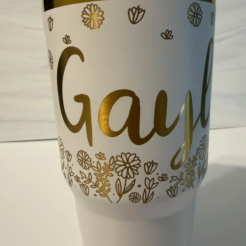 Closeup of laser-engraved name in script font on white and gold electroplated tumbler by Cactus Air Designs
