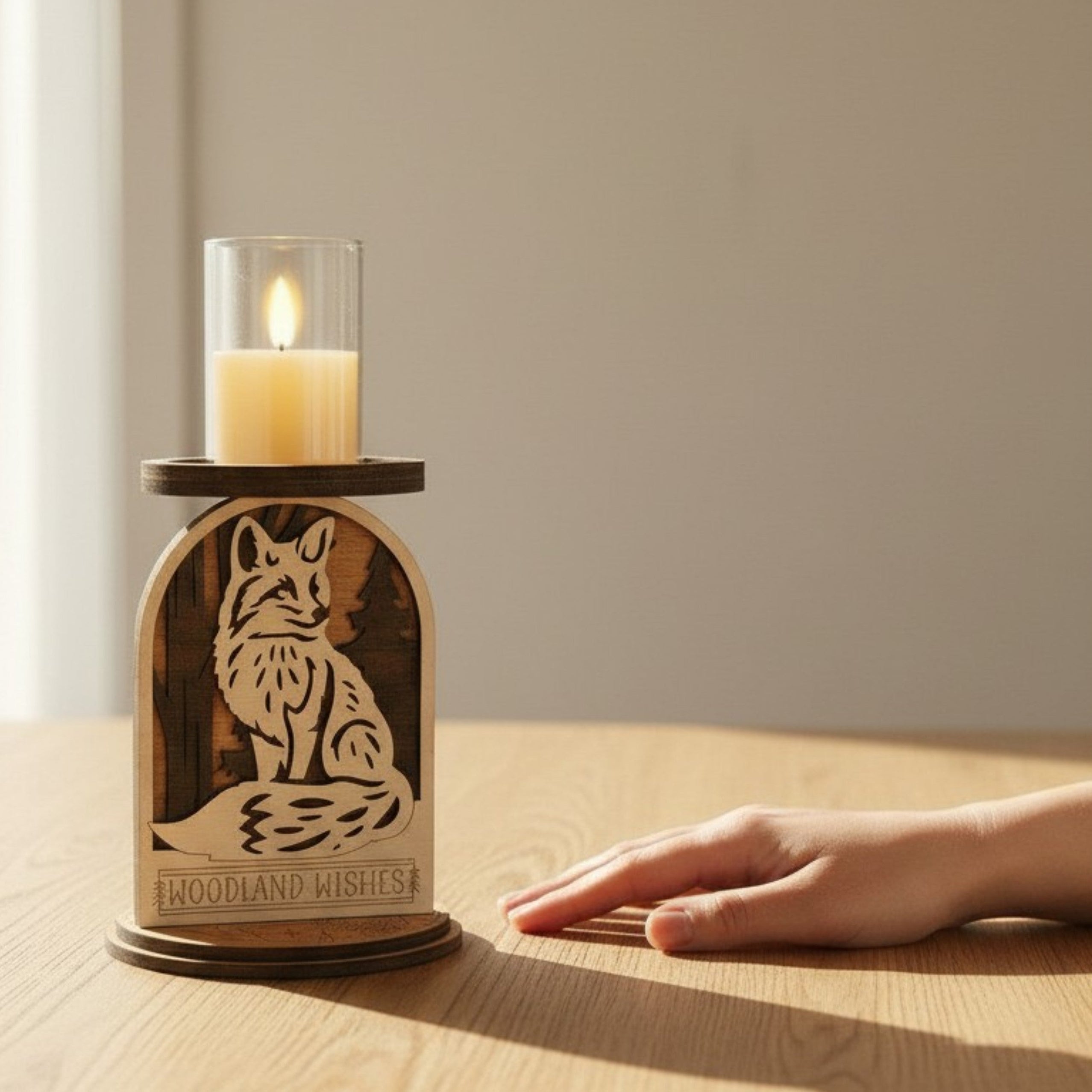 Wooden candle holder with fox design and lit candle on a wooden surface.