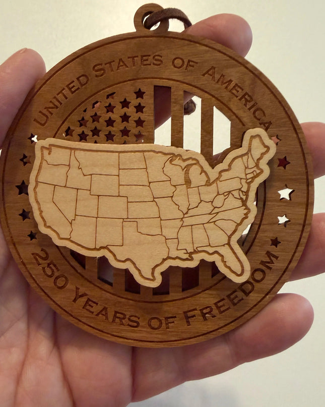 Hand holding USA 250th Anniversary USA Map wood ornament showing actual size approximately 3.5 inches handcrafted by Cactus Air Designs Arizona