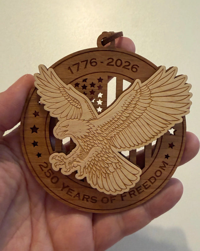 Hand holding USA 250th Anniversary Bald Eagle wood ornament showing actual size approximately 3.5 inches handcrafted by Cactus Air Designs Arizona