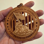 Hand holding USA 250th Anniversary Flag Raising wood ornament showing actual size approximately 3.5 inches handcrafted by Cactus Air Designs Arizona