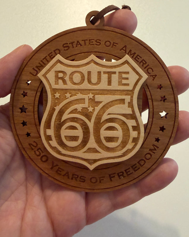 Hand holding USA 250th Anniversary Route 66 wood ornament showing actual size approximately 3.5 inches handcrafted by Cactus Air Designs Arizona