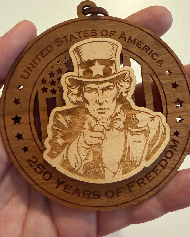 Hand holding USA 250th Anniversary Uncle Sam wood ornament showing actual size approximately 3.5 inches handcrafted by Cactus Air Designs Arizona