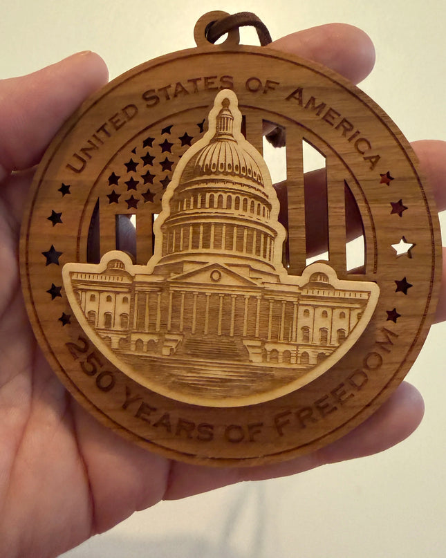 Hand holding USA 250th Anniversary US Capitol wood ornament showing actual size approximately 3.5 inches handcrafted by Cactus Air Designs Arizona