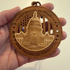 Hand holding USA 250th Anniversary US Capitol wood ornament showing actual size approximately 3.5 inches handcrafted by Cactus Air Designs Arizona