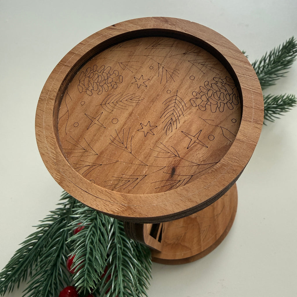 Top view of laser-cut woodland wildlife candle holder showing engraved branches, acorns, stars, and circles