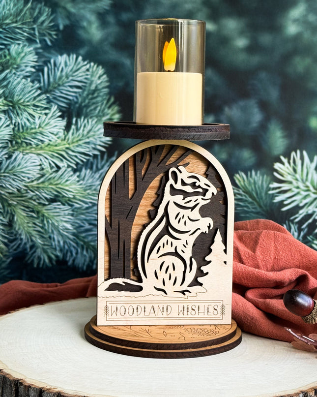 Decorative candle holder with chipmunk design and 'Woodland Wishes' text, set against a natural background.