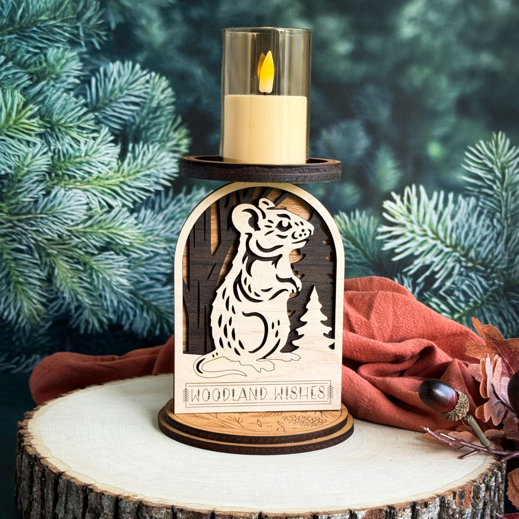 Wooden candle holder with a mouse design and 'Woodland Wishes' text, set against a natural background.