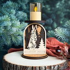Wooden candle holder with rabbit design on a tree stump against a forest background