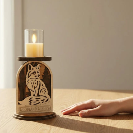 Hand near layered wood woodland fox candle holder on a modern wood table in natural window light showing size scale
