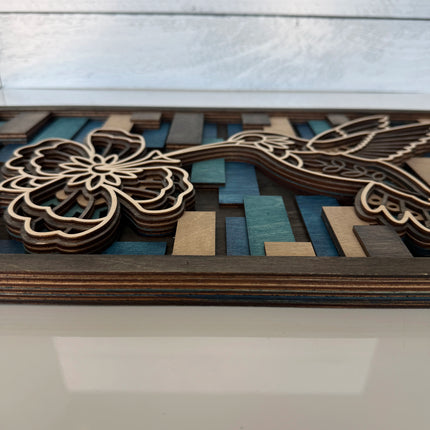 Side profile of hummingbird layered wood wall art showing stacked plywood layers and frame construction depth