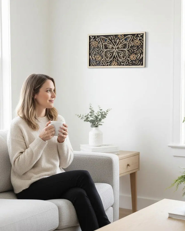 Person holding a coffee mug admiring a 3D layered butterfly wood wall art on a white wall showing the scale of the 18 by 10.5 inch piece
