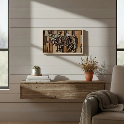 A framed wall art piece featuring a stylized cow on a wood-plank background, displayed above a floating wooden console in a modern living room setting.