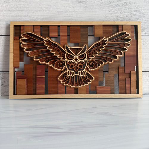 Front view of a 3D flying owl wall art made of five layers of laser-cut wood with warm brown and reddish-toned geometric bar accents