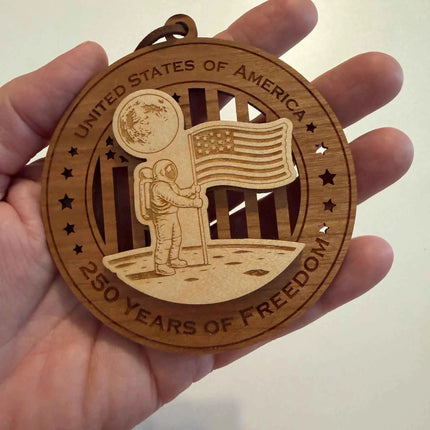 USA 250th anniversary Astronaut with moon and American flag wood ornament held in hand showing approximately 3.5 inch size
