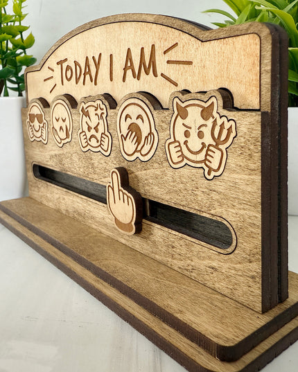 Angled view of natural maple Today I Am emoji mood board showing sliding track and five engraved emoji faces