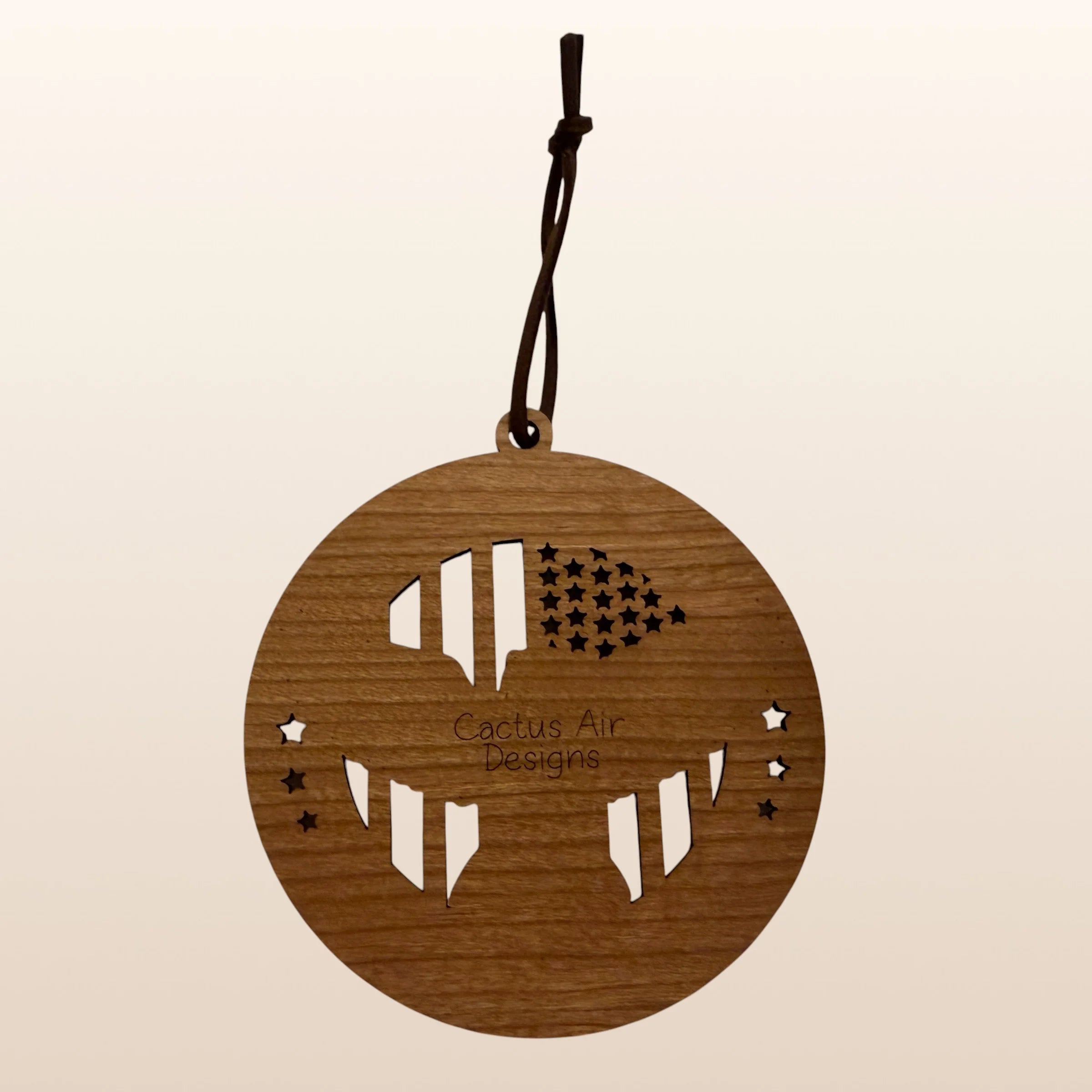 Back of USA 250th Anniversary Eagle Flag Shield ornament showing Cactus Air Designs maker's mark on Premium Cherry plywood with leather cord hanger