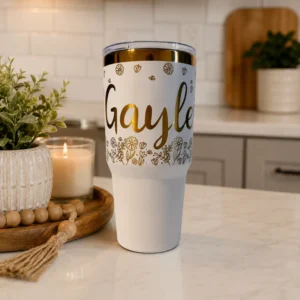 Personalized white and gold electroplated tumbler with hand drawn flowers with a name all engraved.