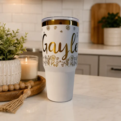 Personalized white and gold electroplated tumbler with hand drawn flowers with a name all engraved.