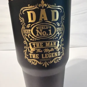 Close-up of the gold Dad Man Myth Legend engraving on a black tumbler