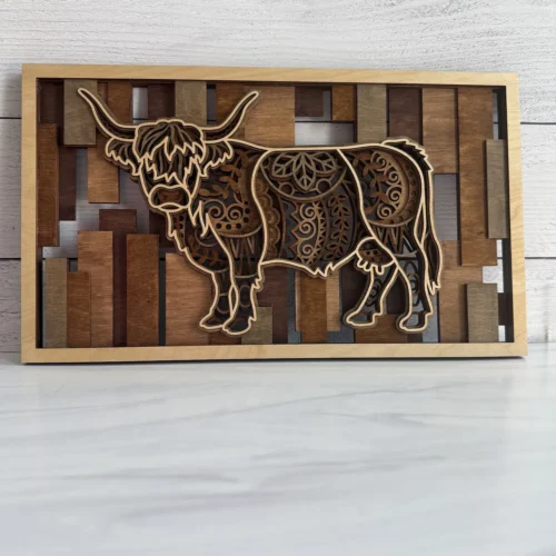 Layered highland cow wall art with mandala engravings, natural maple frame, and mosaic stained slat background
