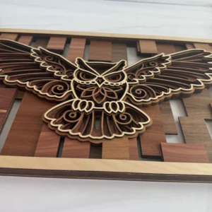 Side profile of flying owl layered wall art showing stacked layer depth and natural maple frame edge