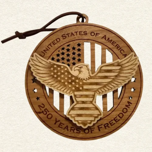 Round two-tone wood ornament featuring a spread-wing bald eagle patterned with stars and stripes, engraved “United States of America” and “250 Years of Freedom.”