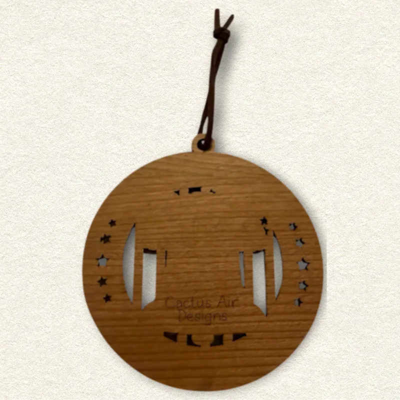 Back of the round wooden ornament showing the natural wood grain, an attached brown hanging cord, and “Cactus Air Designs” laser engraved in a delicate single-line font.