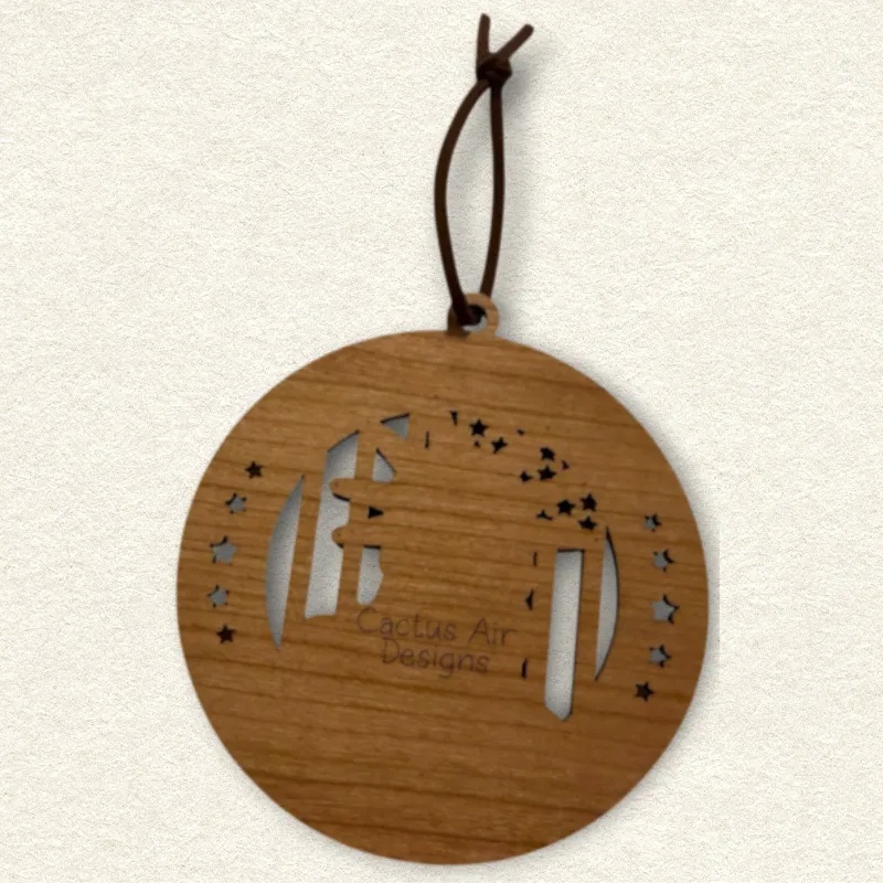 Back of the round wooden ornament showing the natural wood grain, an attached brown hanging cord, and “Cactus Air Designs” laser engraved in a delicate single-line font.