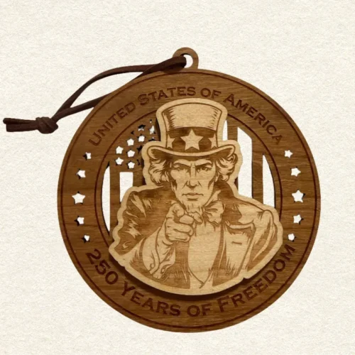Round two-layer wooden ornament with "United States of America" and "250 Years of Freedom" engraved on the border, featuring a laser-cut flag with cut-through stripes and star field, topped with a detailed Uncle Sam pointing his finger at you, hung on a brown cord