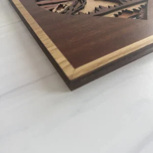 Close-up of cherry frame and layered walnut evergreen details
