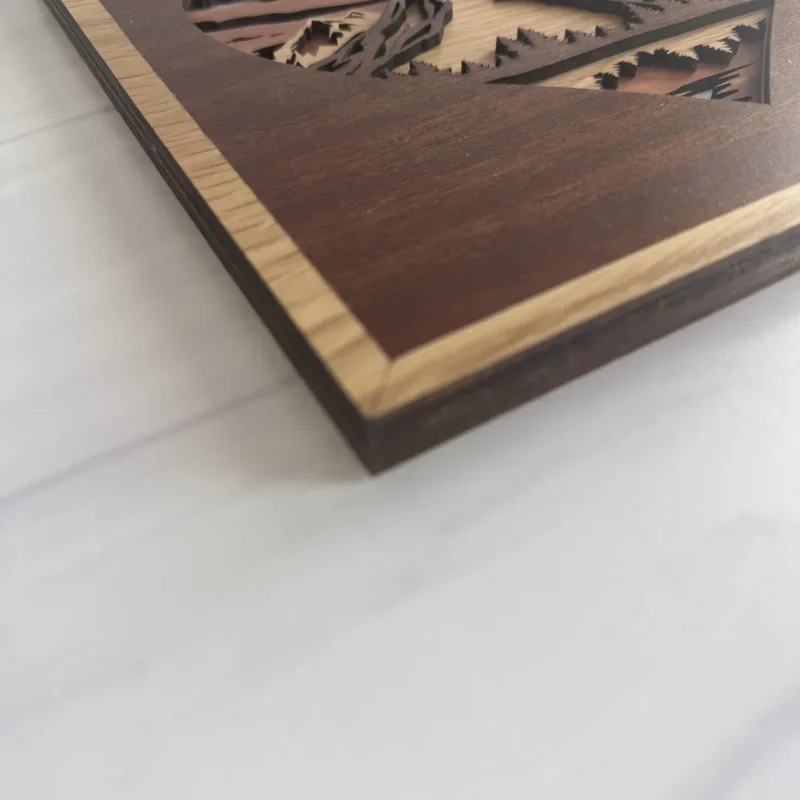 Close-up of cherry frame and layered walnut evergreen details